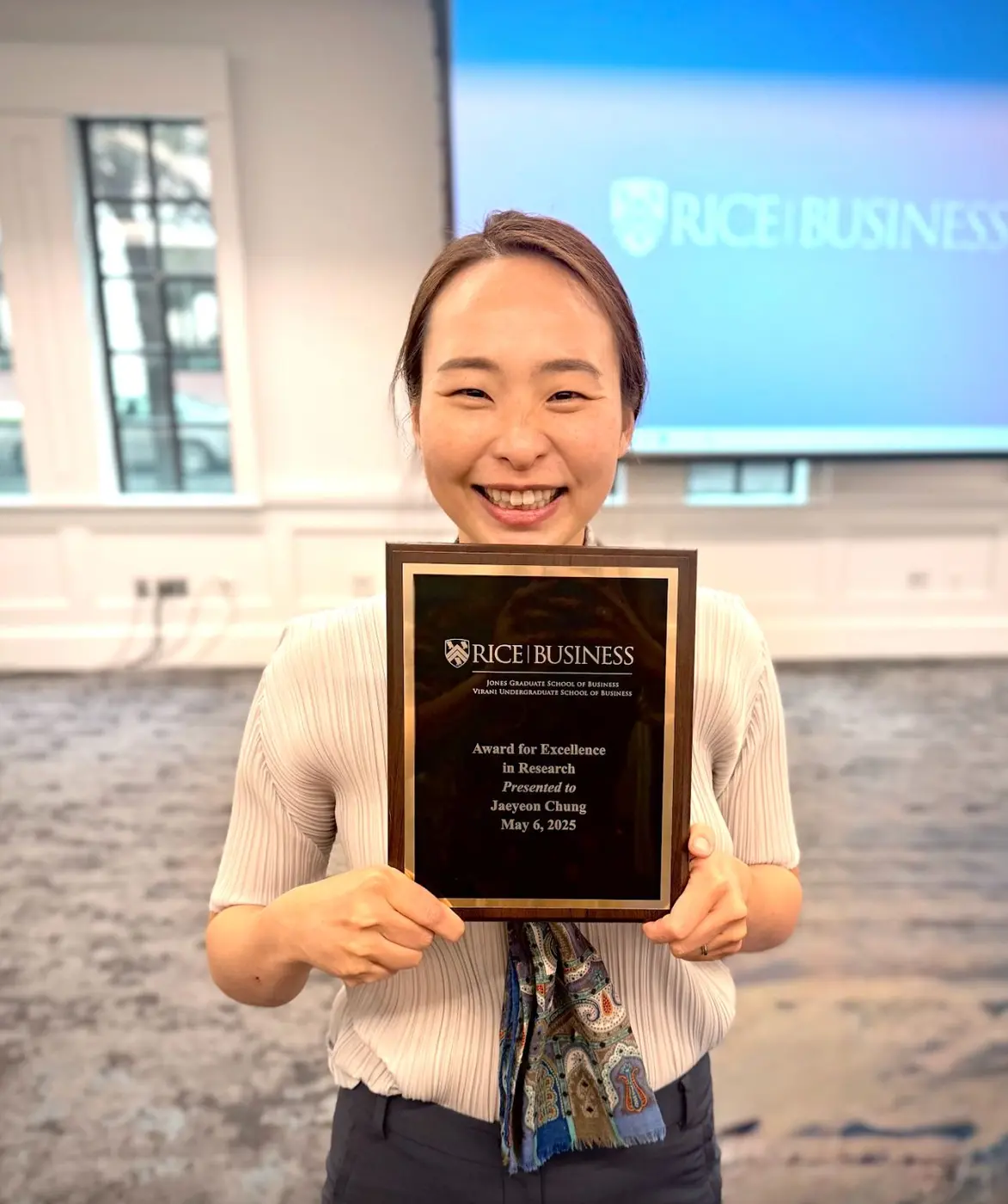Jaeyeon Chung holding the Rice Business Award for Excellence in Research